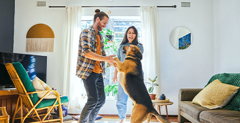 Couple dancing with a Dog in their new living room