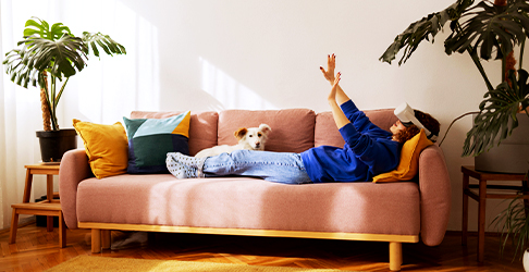 Woman Laying On Couch interacting with VR Headset