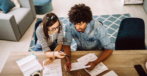 Couple sitting at their kitchen table working through their financial document