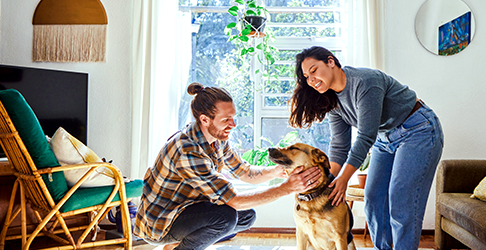 Couple Petting Dog in New Home
