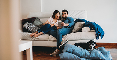 Couple on a couch with their dog in a clean home