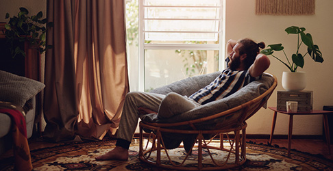 Man leaning back in lounge chair in living room